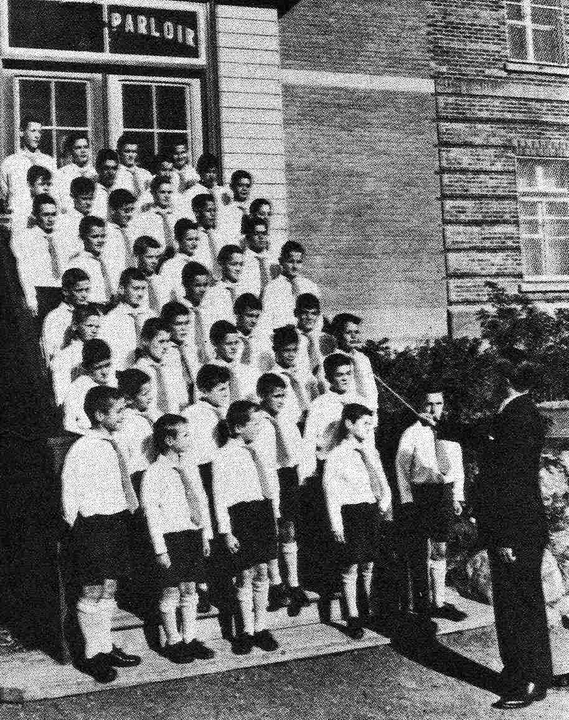 Des enfants hébergés au pavillon La Jemmerais chantent en choeur, installés dans un escalier extérieur