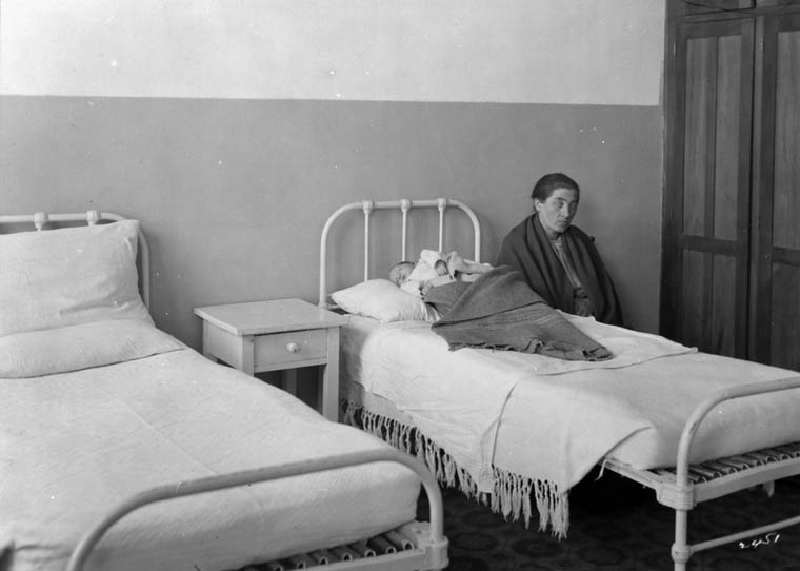 Une immigrante veille un tout jeune enfant soigné à l'Hôpital de l'immigration vers 1911